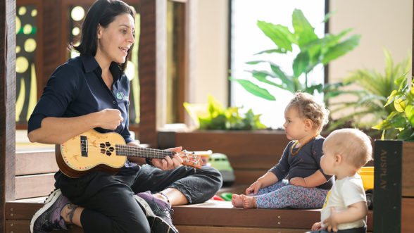 Teacher playing instrument to two children