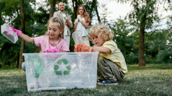 Two children putting recycling into the recycling bin