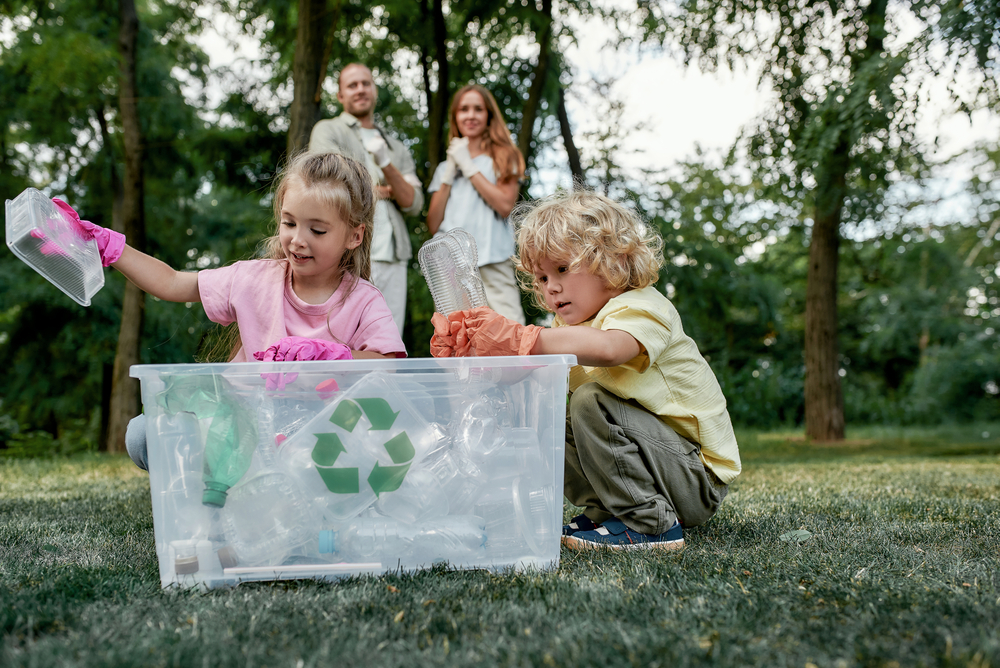 Two children putting recycling into the recycling bin
