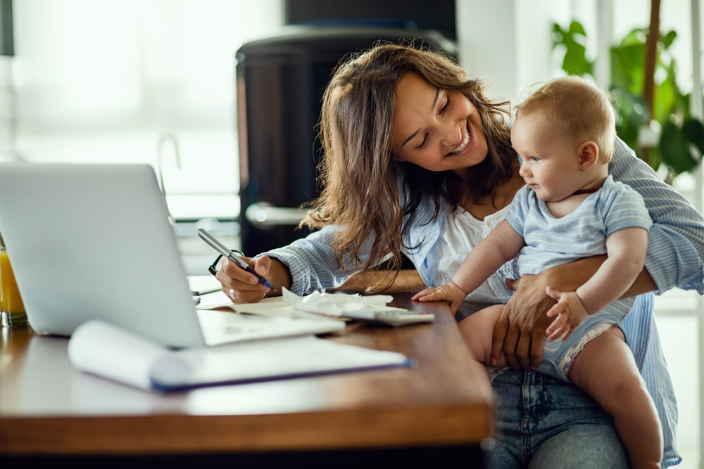 Mother holding baby doing paperwork