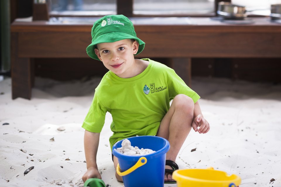 Kindergarten boy playing in the sandpit at an outdoor play area at a childcare in Maryborough