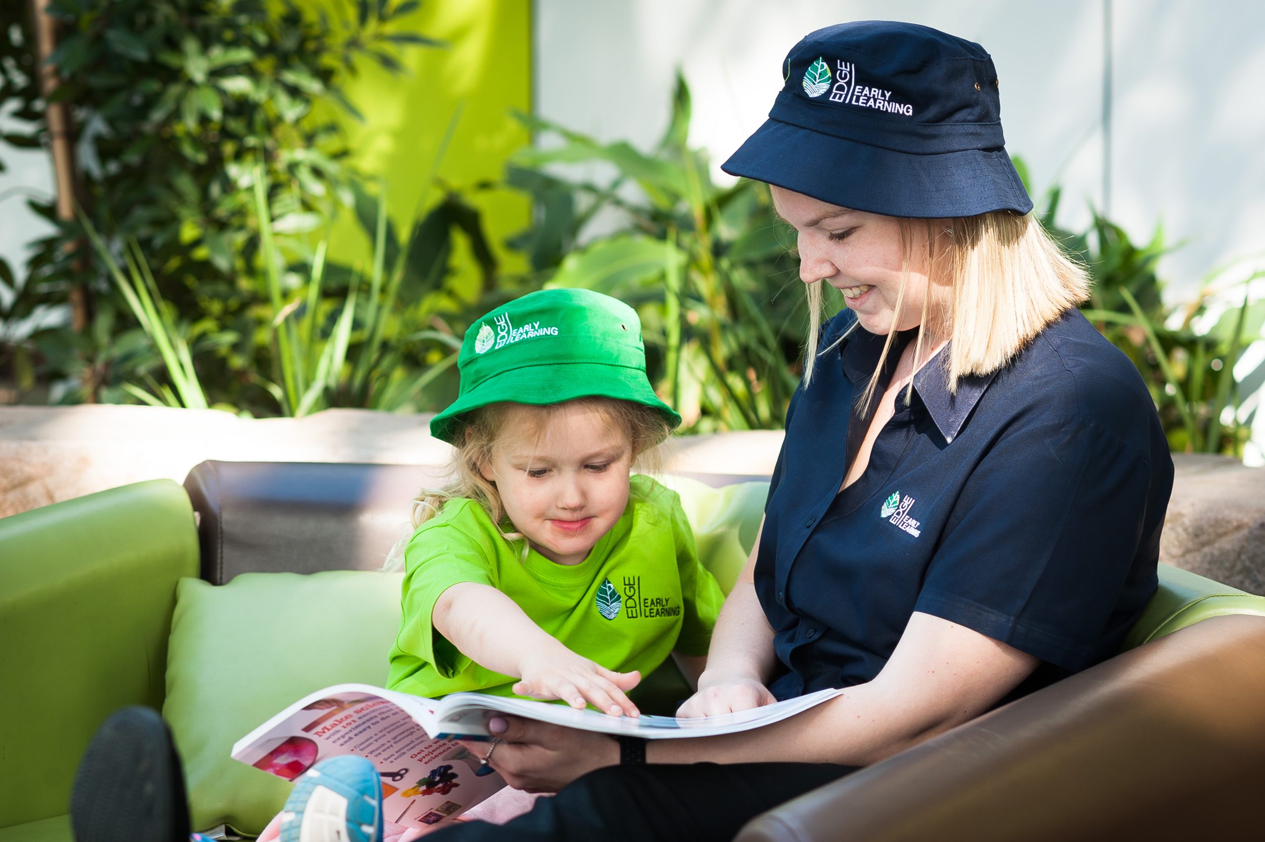 Educator reading a book to a toddler at Maryborough daycare