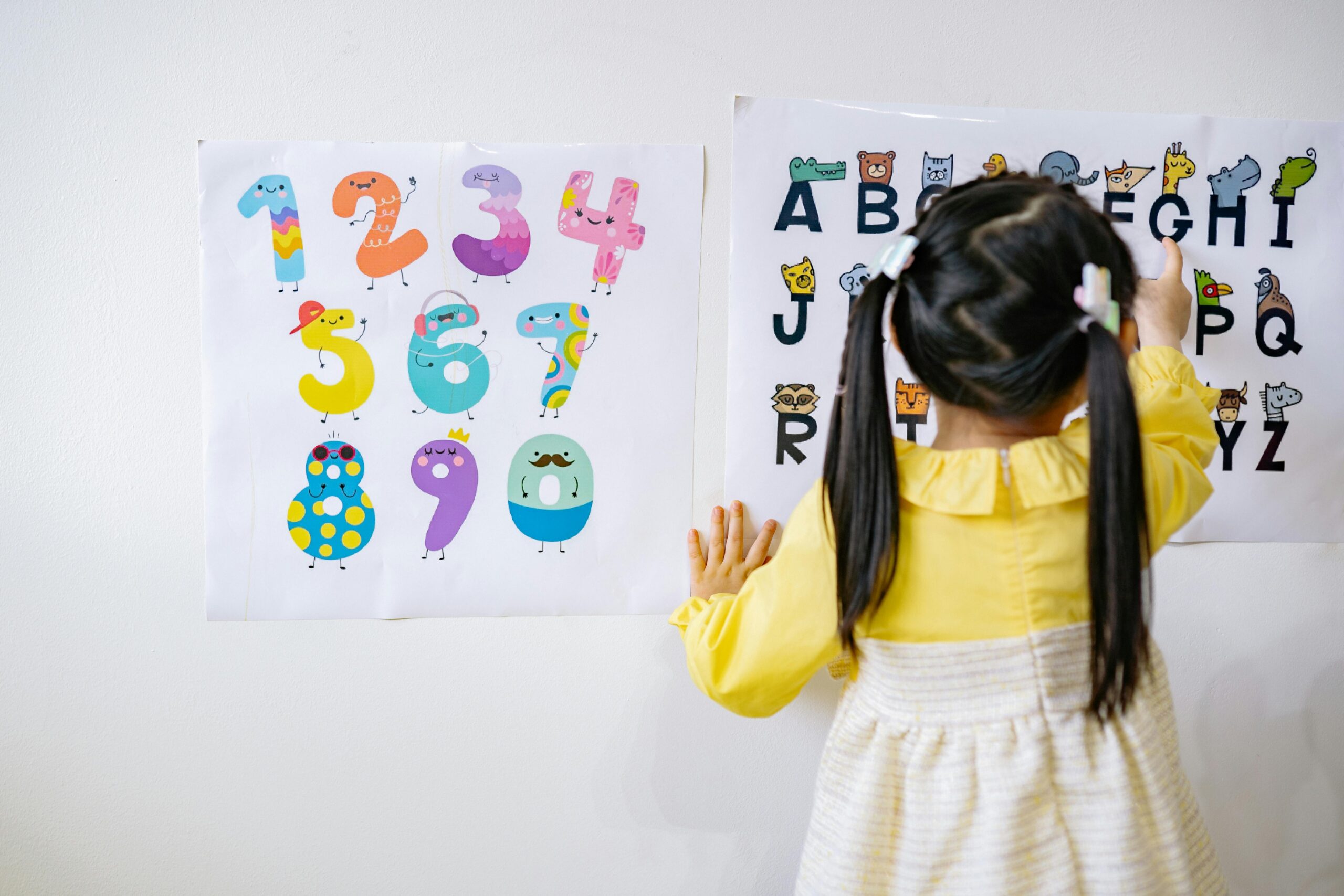 A child writing letters on a piece of paper.
