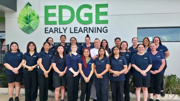 Team of early childhood educators infront on building with signage saying "Edge Early Learning".
