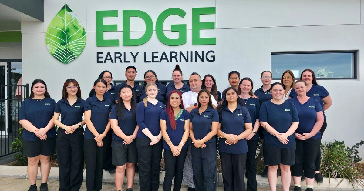 Team of early childhood educators infront on building with signage saying "Edge Early Learning".